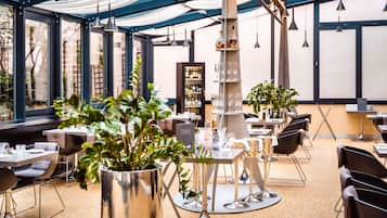 Ein modernes Restaurant mit runden Tischen, Stühlen und einer zentralen Bar.