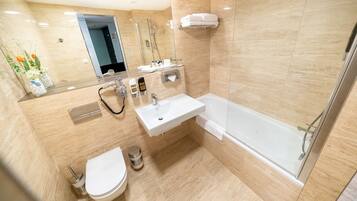 Ein modernes Badezimmer mit einer gläsernen Duschkabine, einem weißen Waschbecken und einer Toilette.