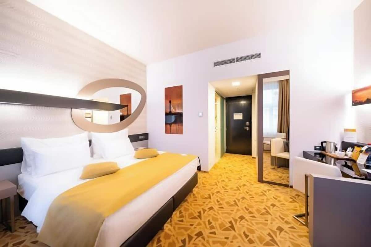 Ein Hotelzimmer mit einem Bett, einem Schreibtisch und einem Spiegel.