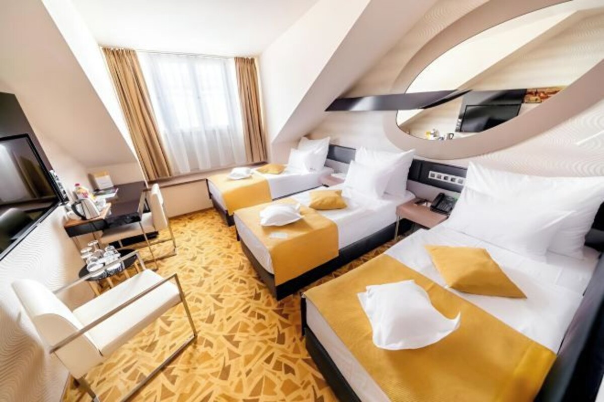 A hotel room with two beds, a desk, a TV, and a window with curtains.