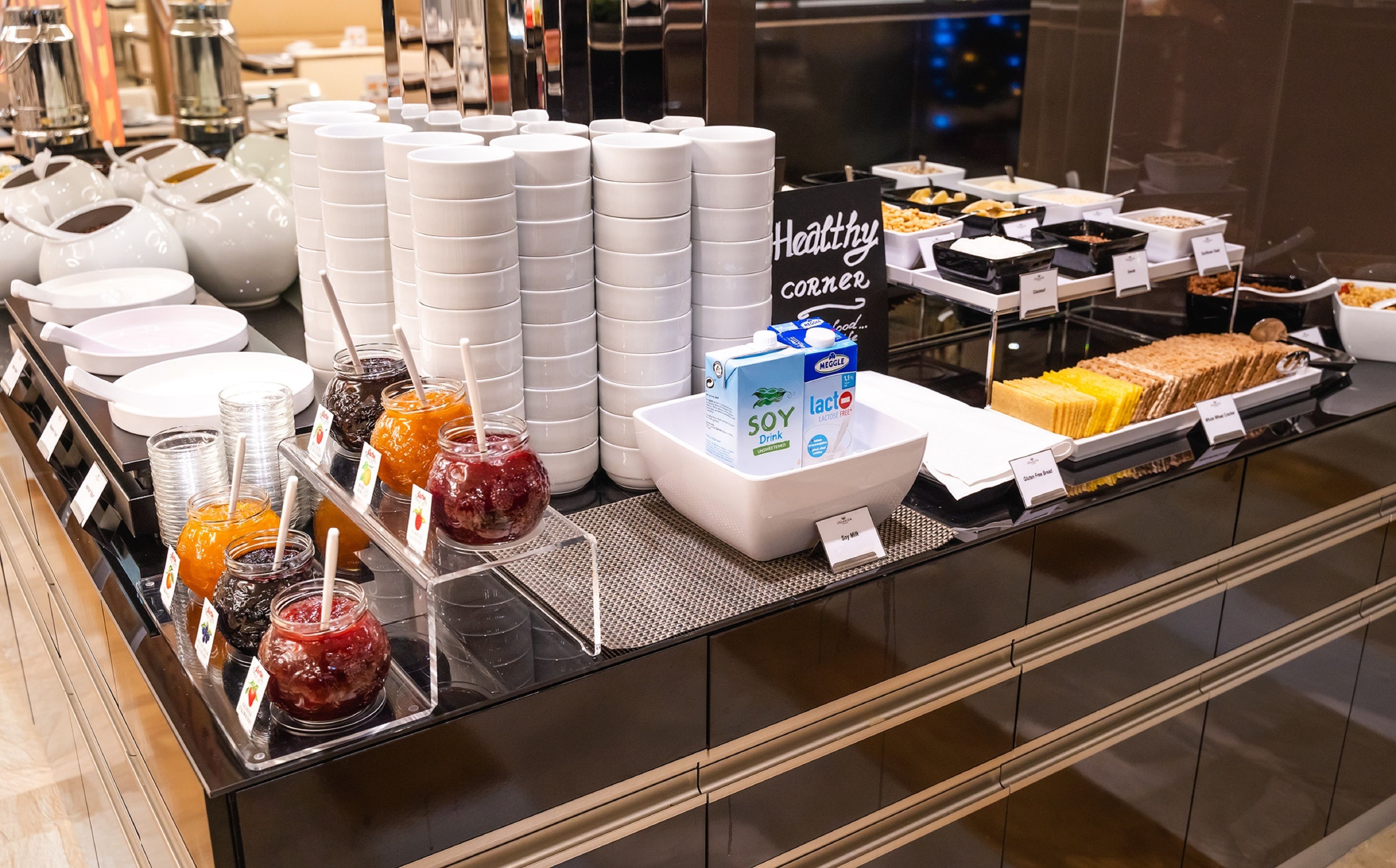A buffet with various food options, including a section labeled "Healthy Corner" with soy milk and lacto-free beverages.