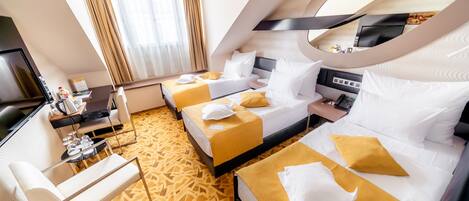 Una habitación de hotel con dos camas, un escritorio, una silla y un televisor.
