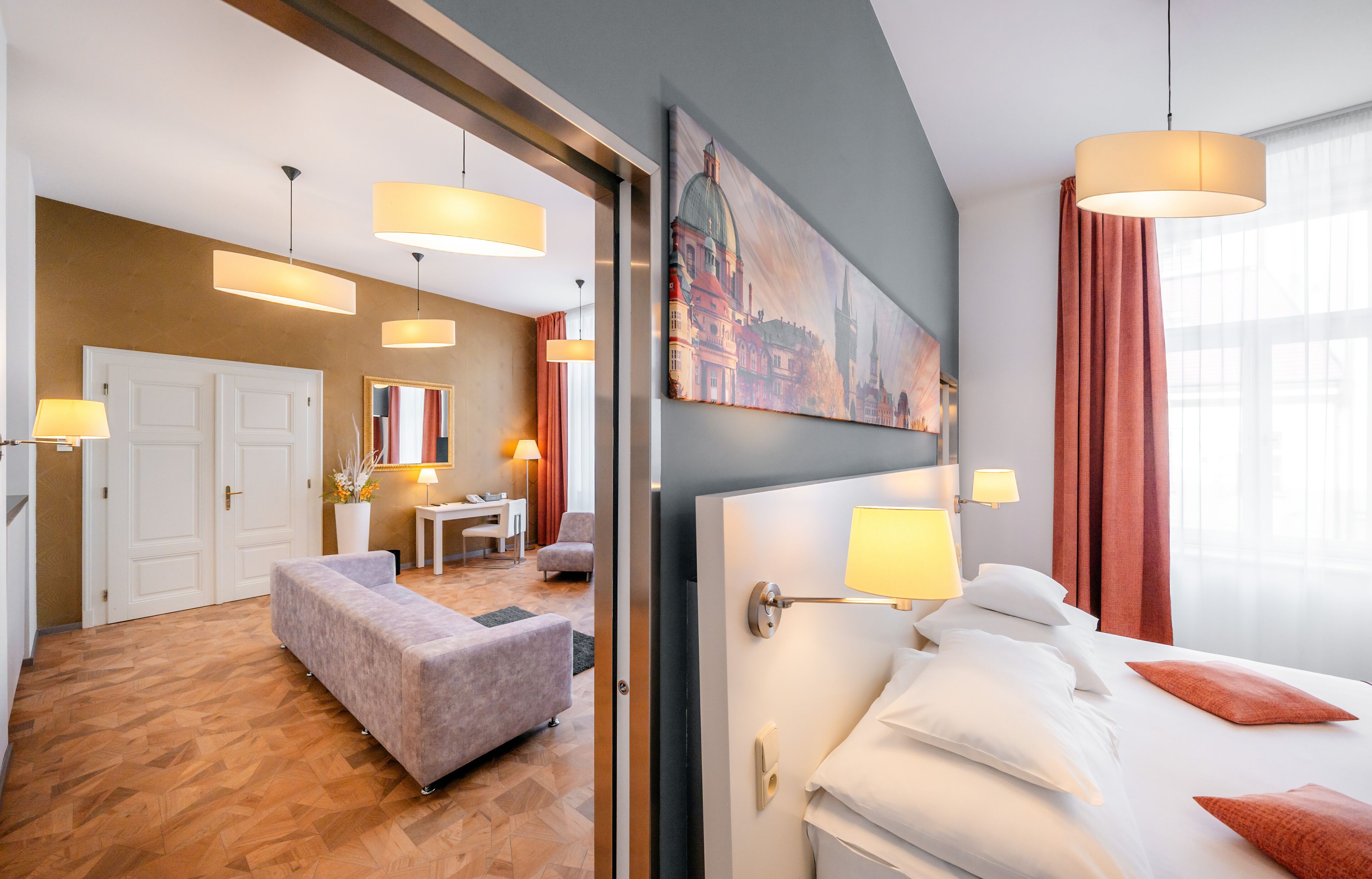 Une chambre d’hôtel avec un lit, des lampes de chevet, un bureau, une chaise et un canapé.