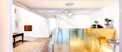 Un interno moderno con una scala, un pavimento in legno e un'area bar.
