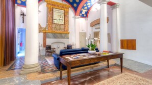 Un vestíbulo amplio con una mesa de centro de madera, un sofá azul y una alfombra estampada.