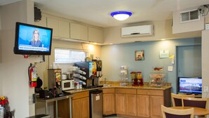 A kitchen with a TV, microwave, refrigerator, and a coffee machine. - Townhouse Inn & Suites (Brawley)