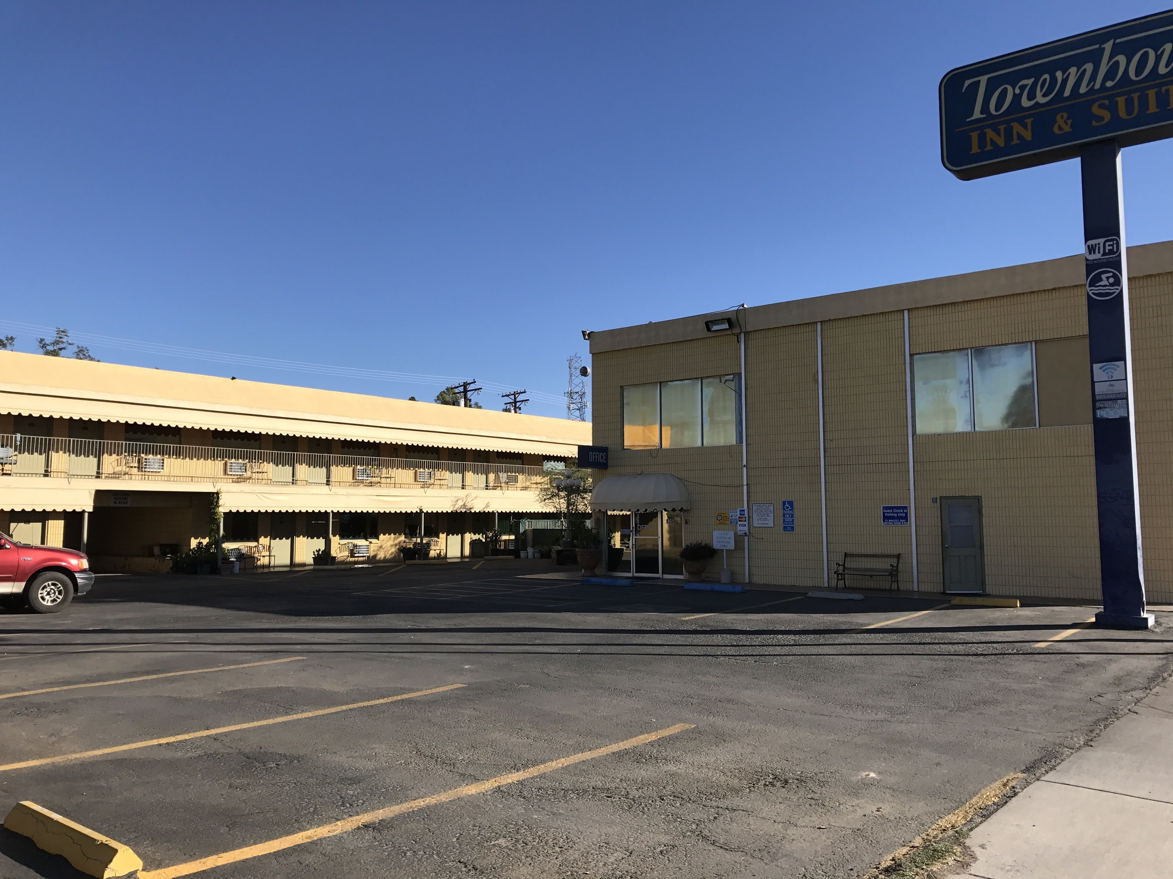 Un edificio de dos pisos con un letrero que dice 'Townhouse Inn & Suites'.