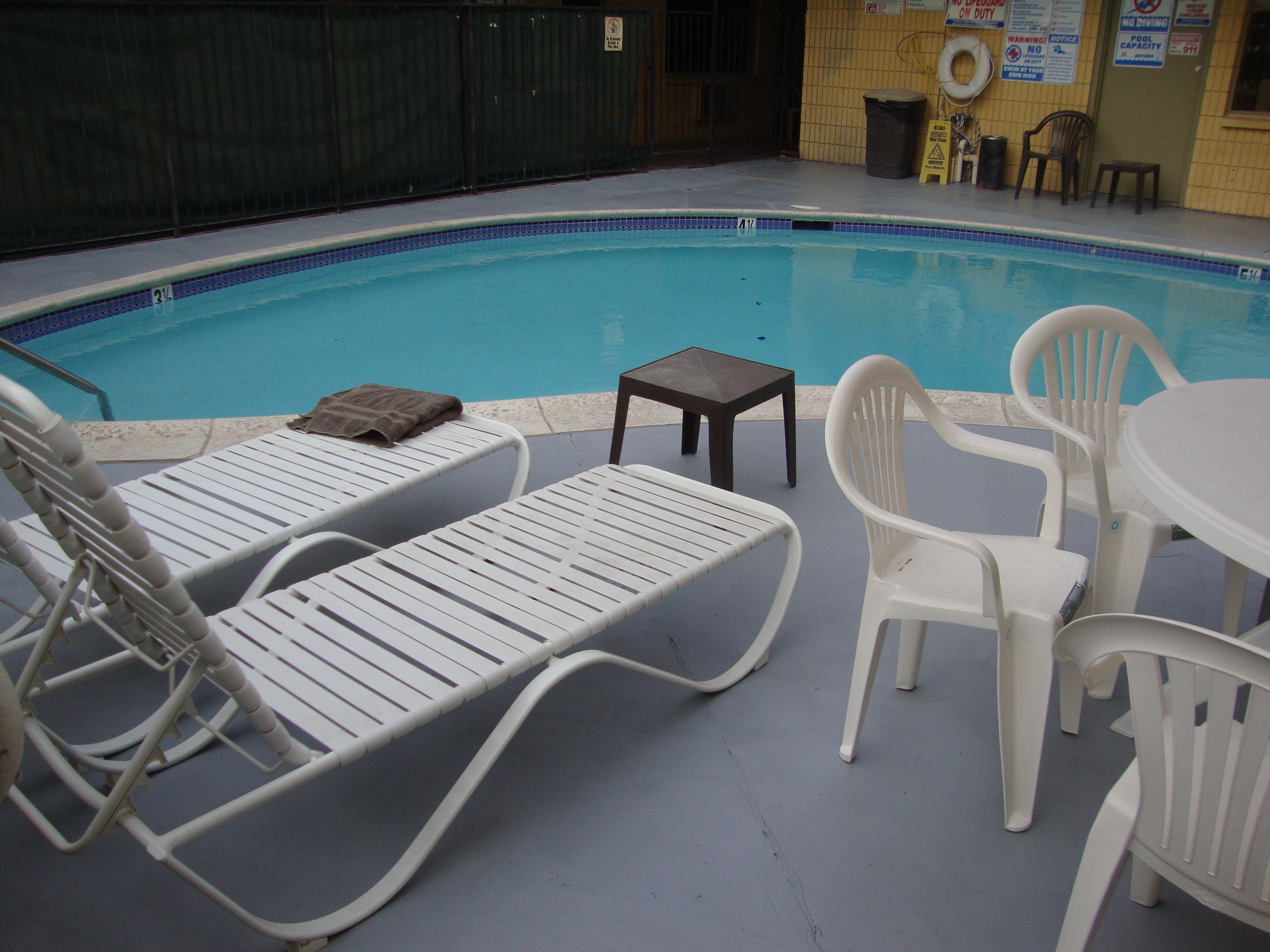 Area piscina con lettini e un tavolo.