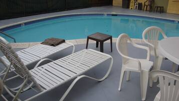 Area piscina con lettini e un tavolo.