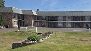 A two-story building with a stone facade, a flat roof, and a front entrance.