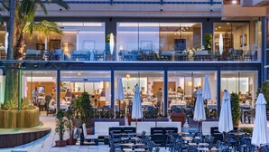 Un hotel con terraza, piscina y restaurante.
