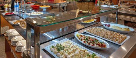 Un buffet proposant une variété de plats et une vitrine réfrigérée.