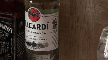 A bottle of Bacardi Carta Blanca on a wooden surface with a menu in front.