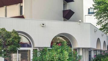 Un edificio moderno con amplias ventanas arqueadas y fachada blanca.