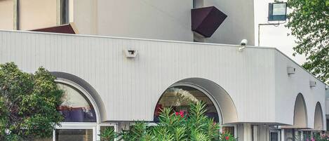 Un edificio moderno con amplias ventanas arqueadas y fachada blanca.