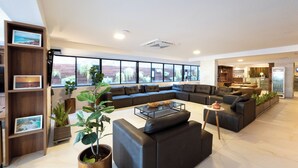 A modern living room with a sectional sofa, a coffee table, and a bookshelf with framed pictures.