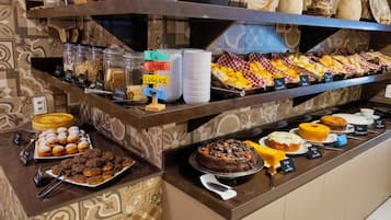 Buffet com diversos alimentos e um aviso indicando a direção ao banheiro.