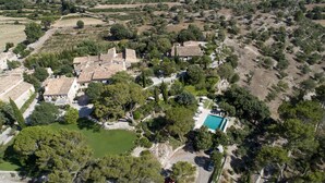 An aerial view of a property with a swimming pool, terraced houses, and surrounding greenery. - Finca Son Palou (Bunyola)