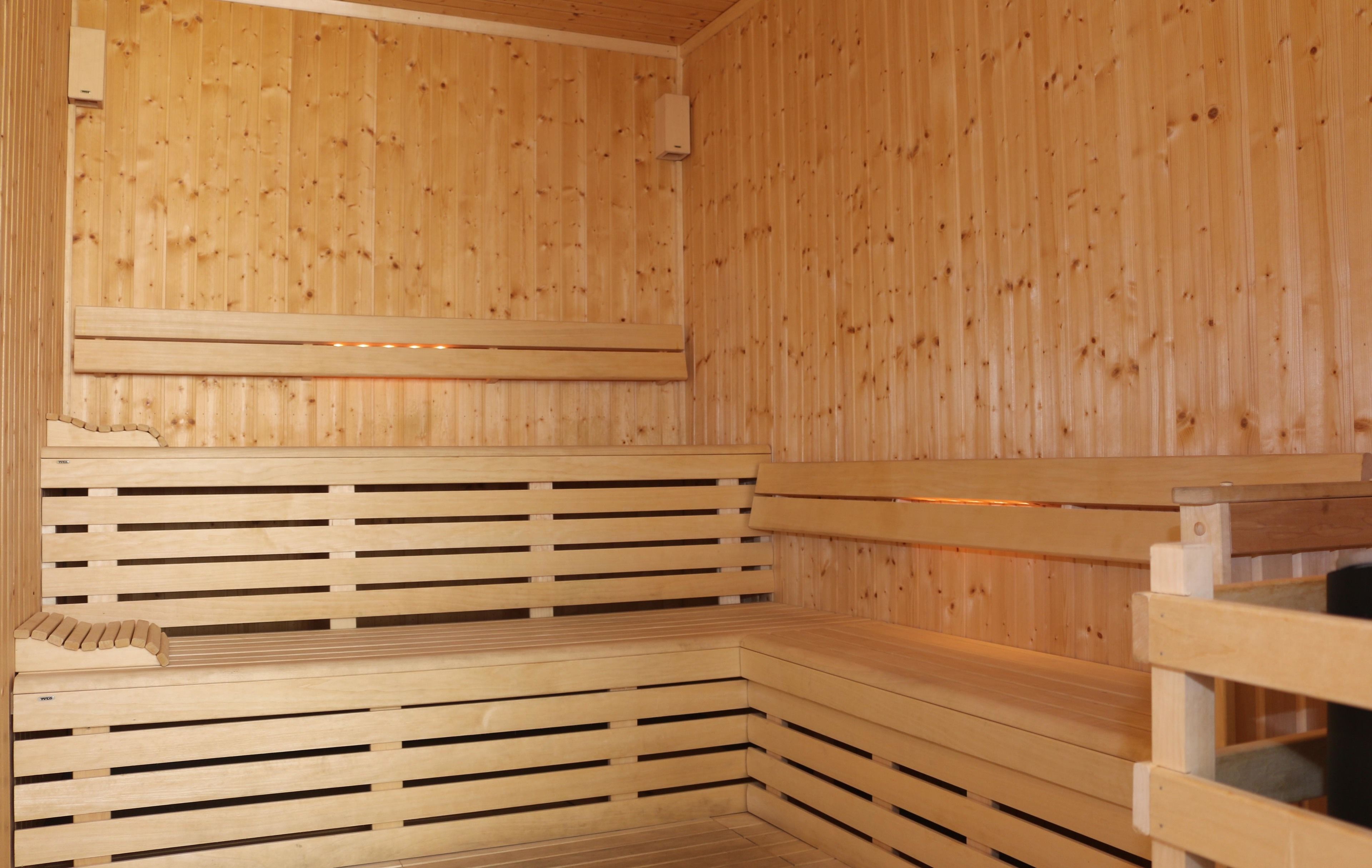 Una sauna de madera con bancos y techo inclinado.