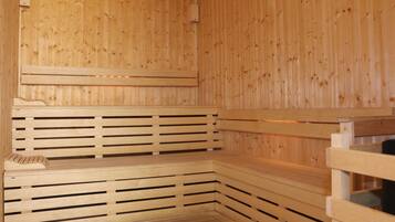 Una sauna de madera con bancos y techo inclinado.