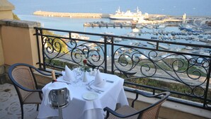 Una mesa lista para comer con vista al puerto y barcos.
