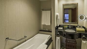 Une salle de bain moderne avec une baignoire, un meuble-lavabo avec un miroir et des toilettes.