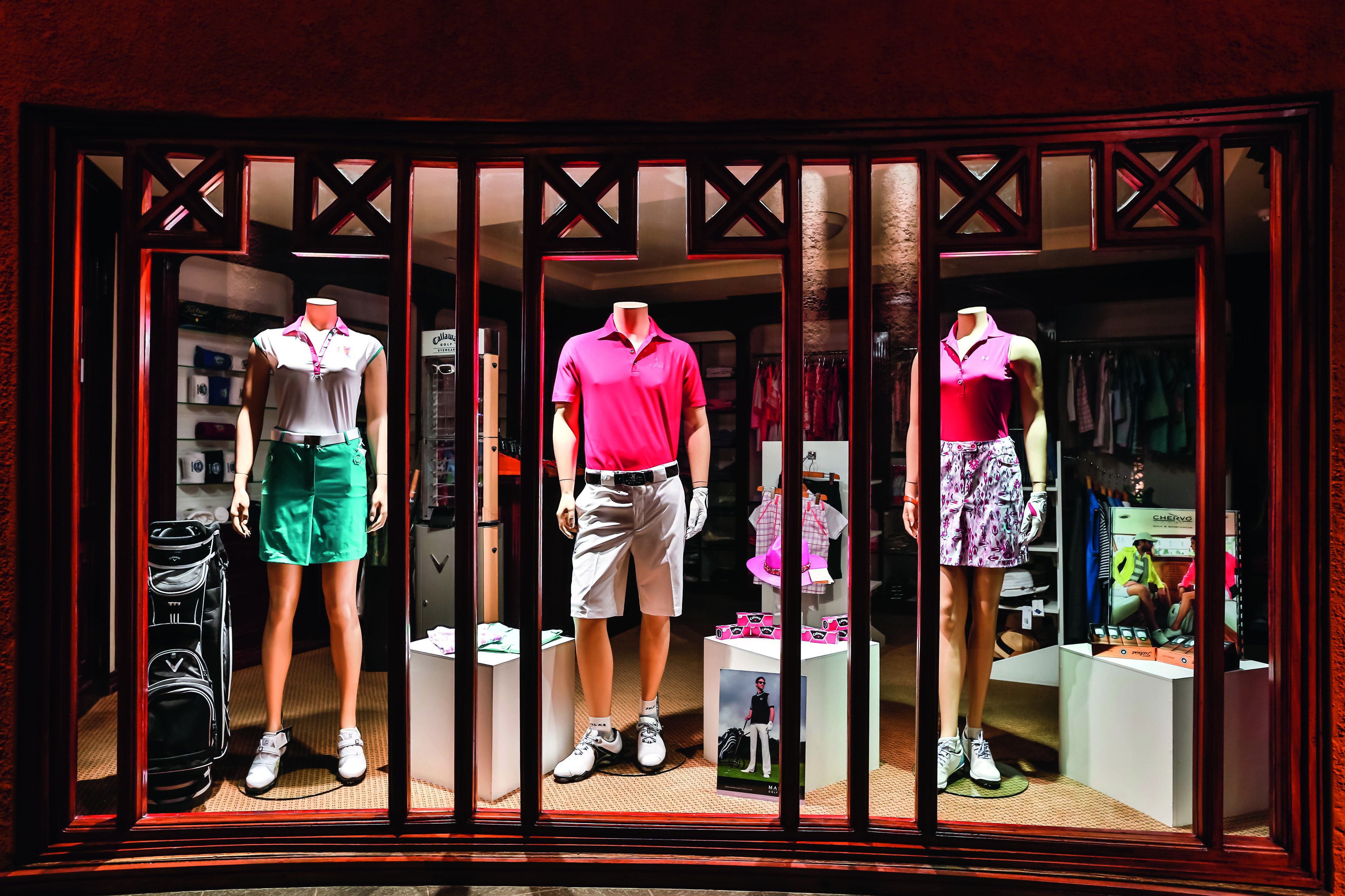 A clothing store window display with mannequins in sportswear.