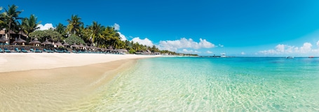 On the beach, white sand, sun loungers, beach umbrellas. Constance Belle Mare Plage
