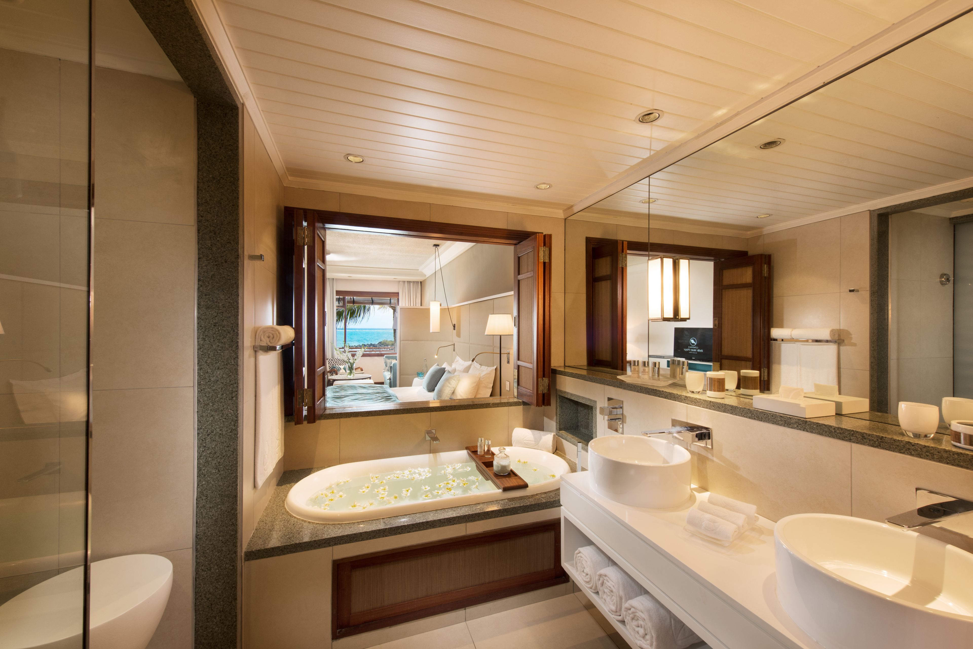 A modern bathroom with a large bathtub, a separate sink, and a vanity.