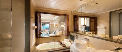 A modern bathroom with a large bathtub, a separate sink, and a vanity.