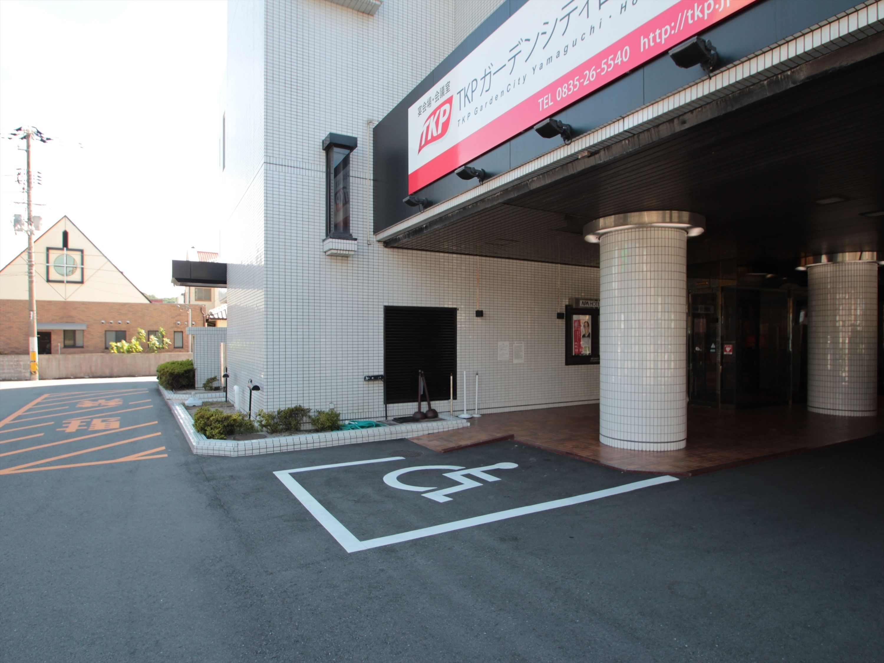 A building entrance with a sign for TKO GardenCity Yamaguchi.