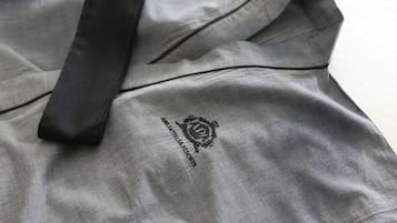 Una bata de hotel gris con una cinta negra y un logotipo que dice 'HOTELRESORTS'.