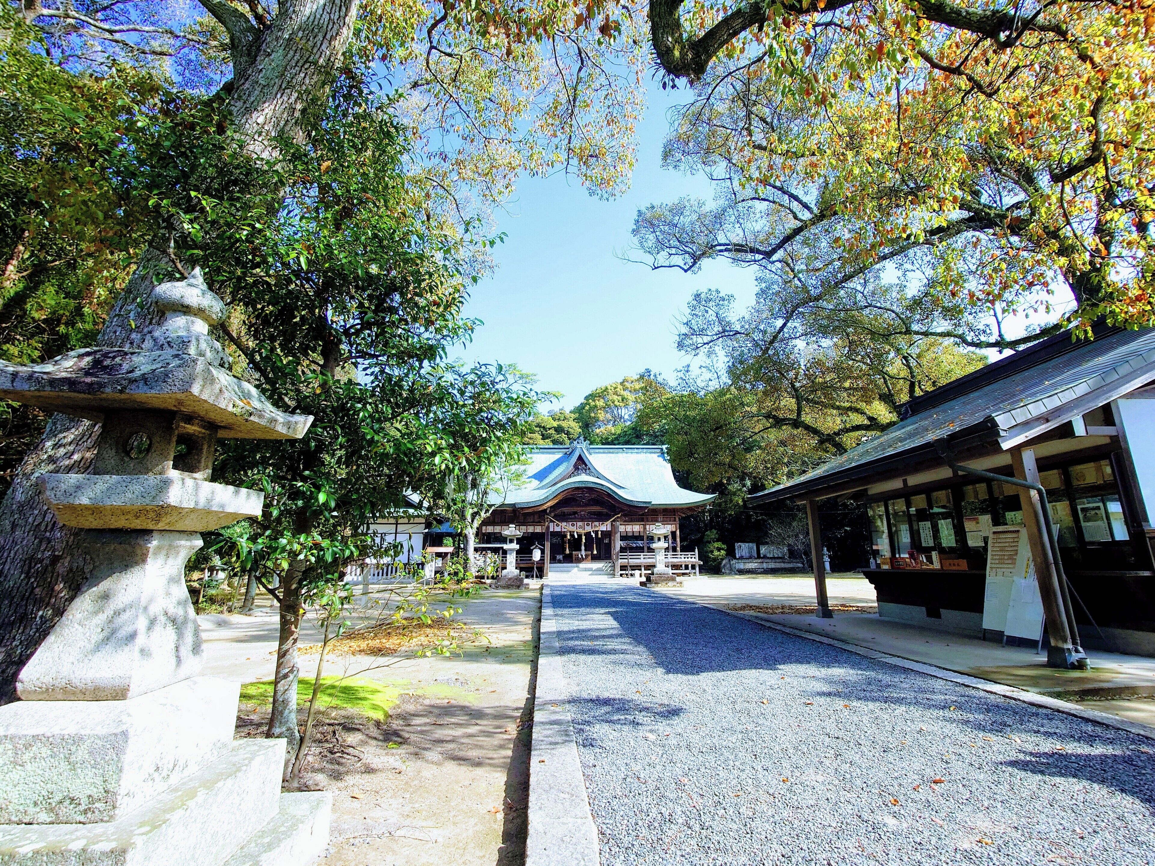 A traditional Japanese temple with a stone lantern and a covered walkway.