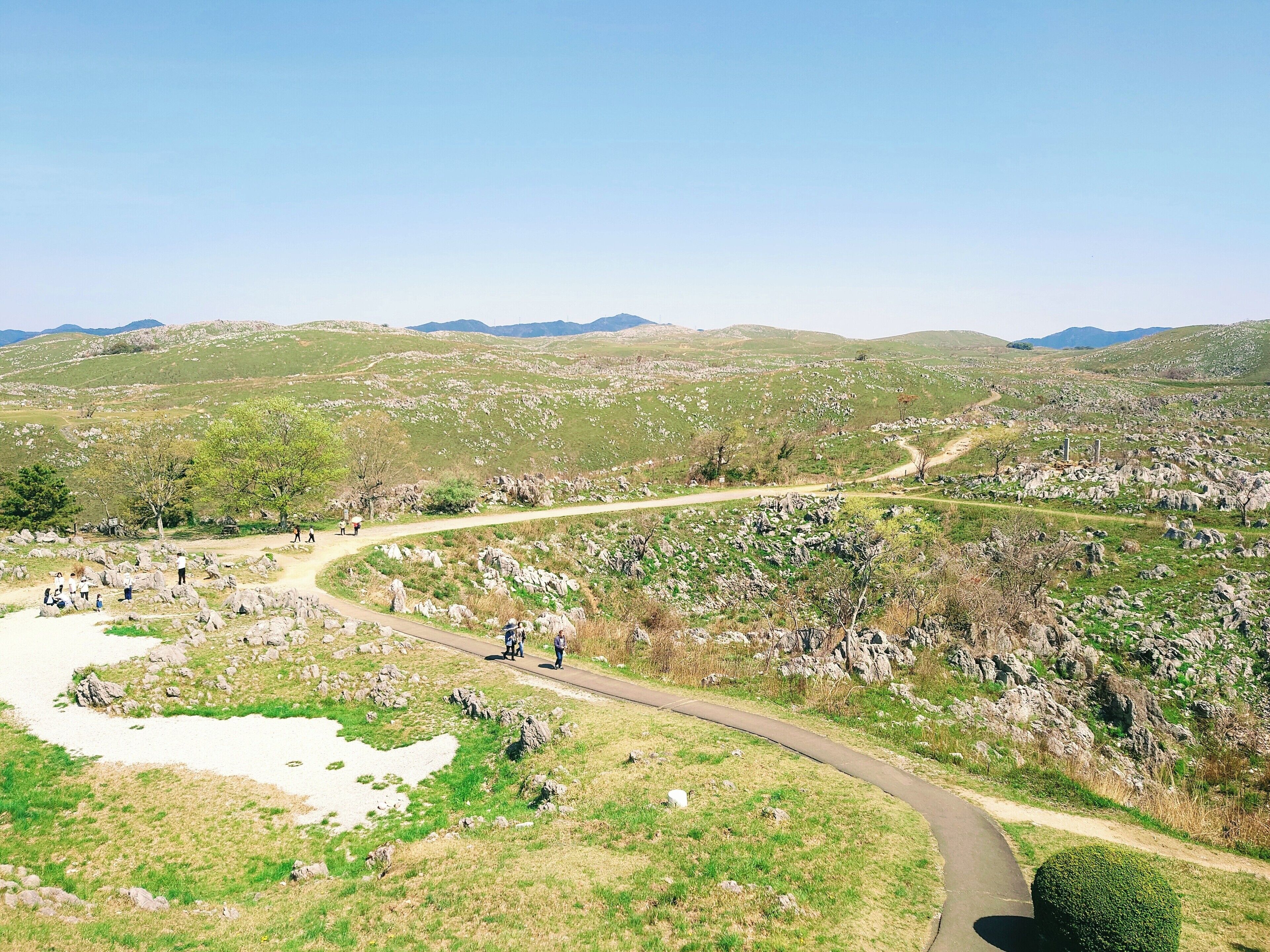 A winding path through a mountainous landscape with rocky terrain and sparse vegetation.