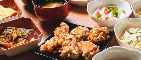 A variety of dishes including fried items, a bowl of soup, and several side dishes.