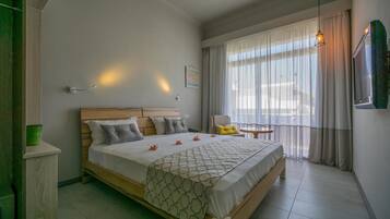 Un dormitorio ordenado con cama, mesita de noche y una pequeña mesa con silla.