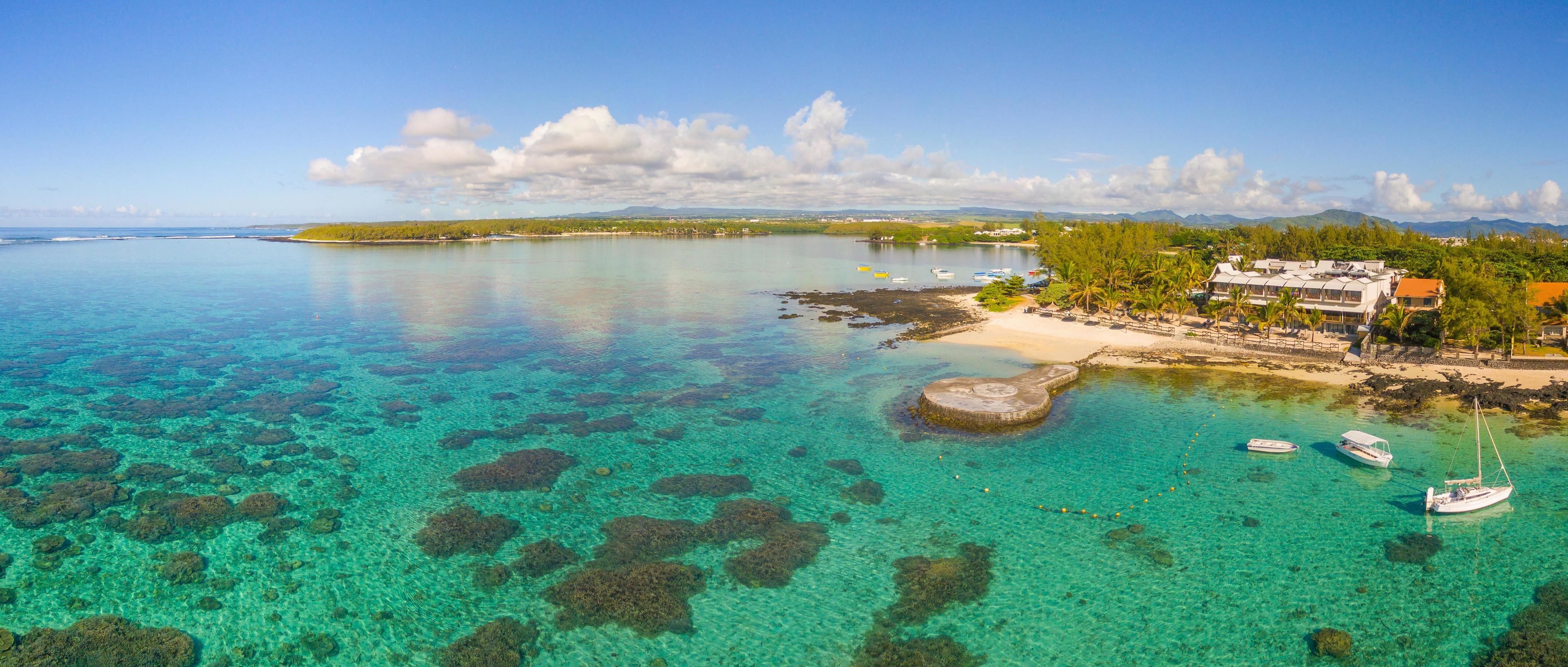 A coastal resort with clear turquoise waters, boats, and a beach.