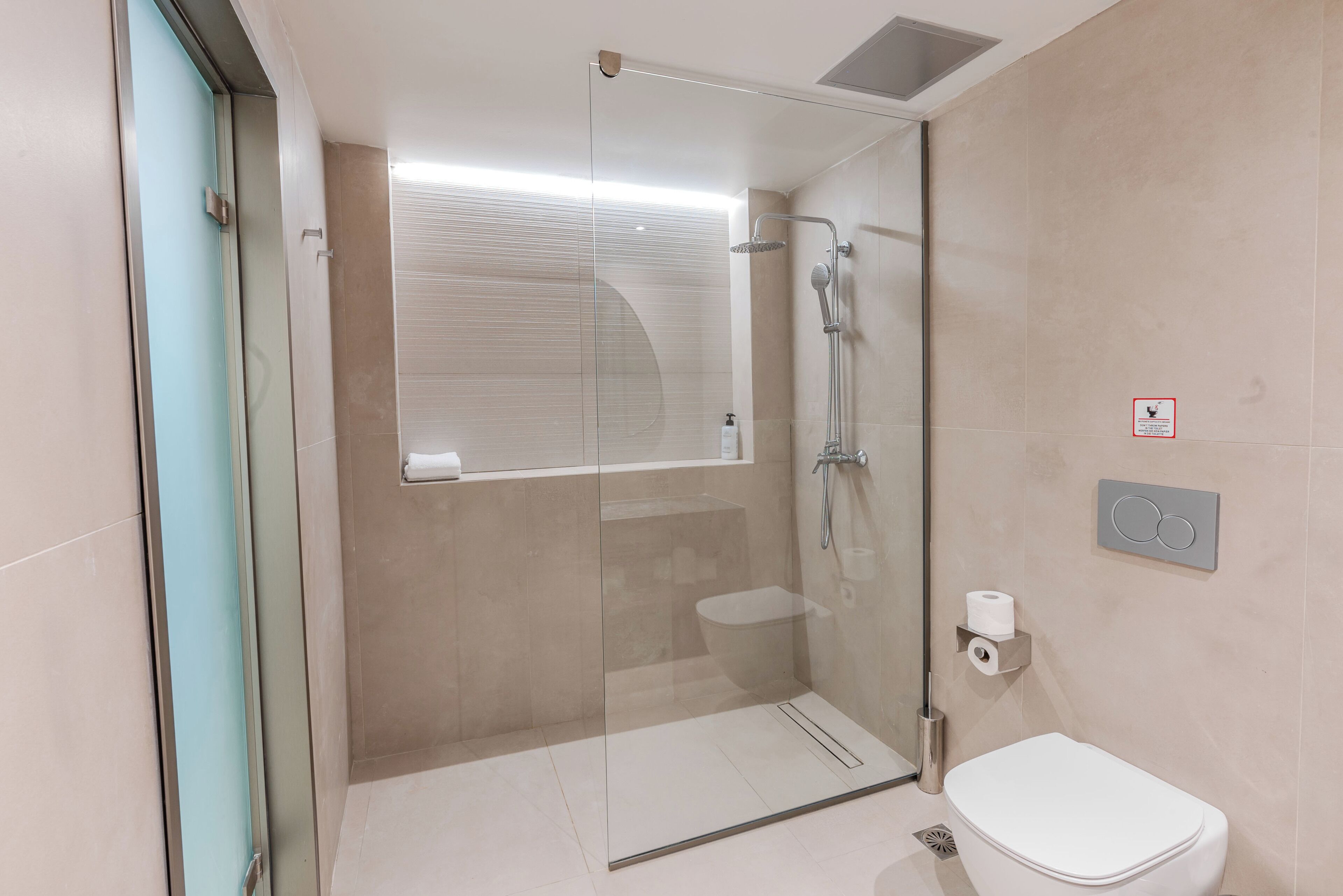 Une salle de bain moderne dotée d’une douche à parois de verre, de toilettes et d’un bidet.