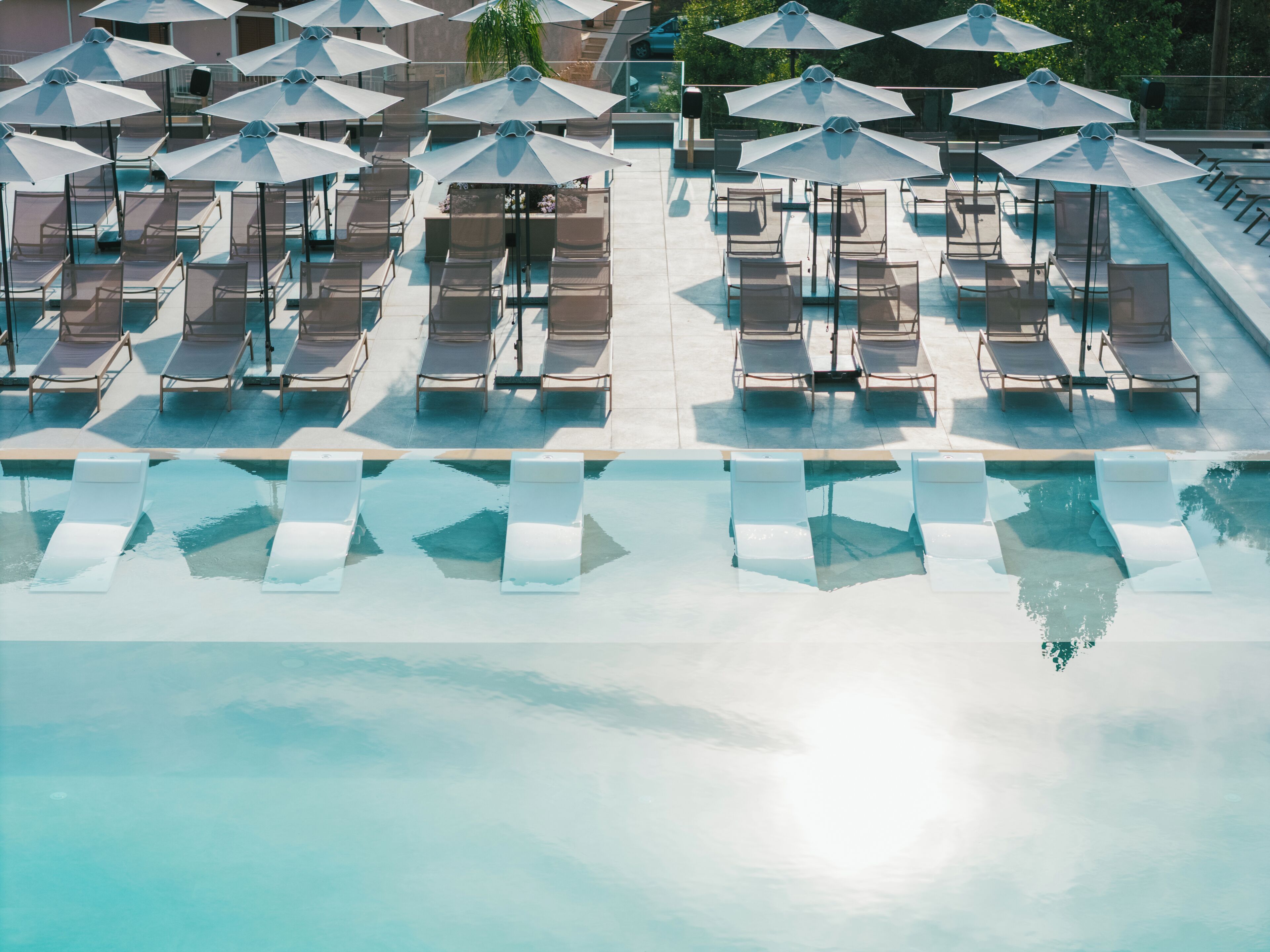 A poolside area with lounge chairs and umbrellas.