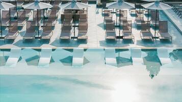 A poolside area with lounge chairs and umbrellas.