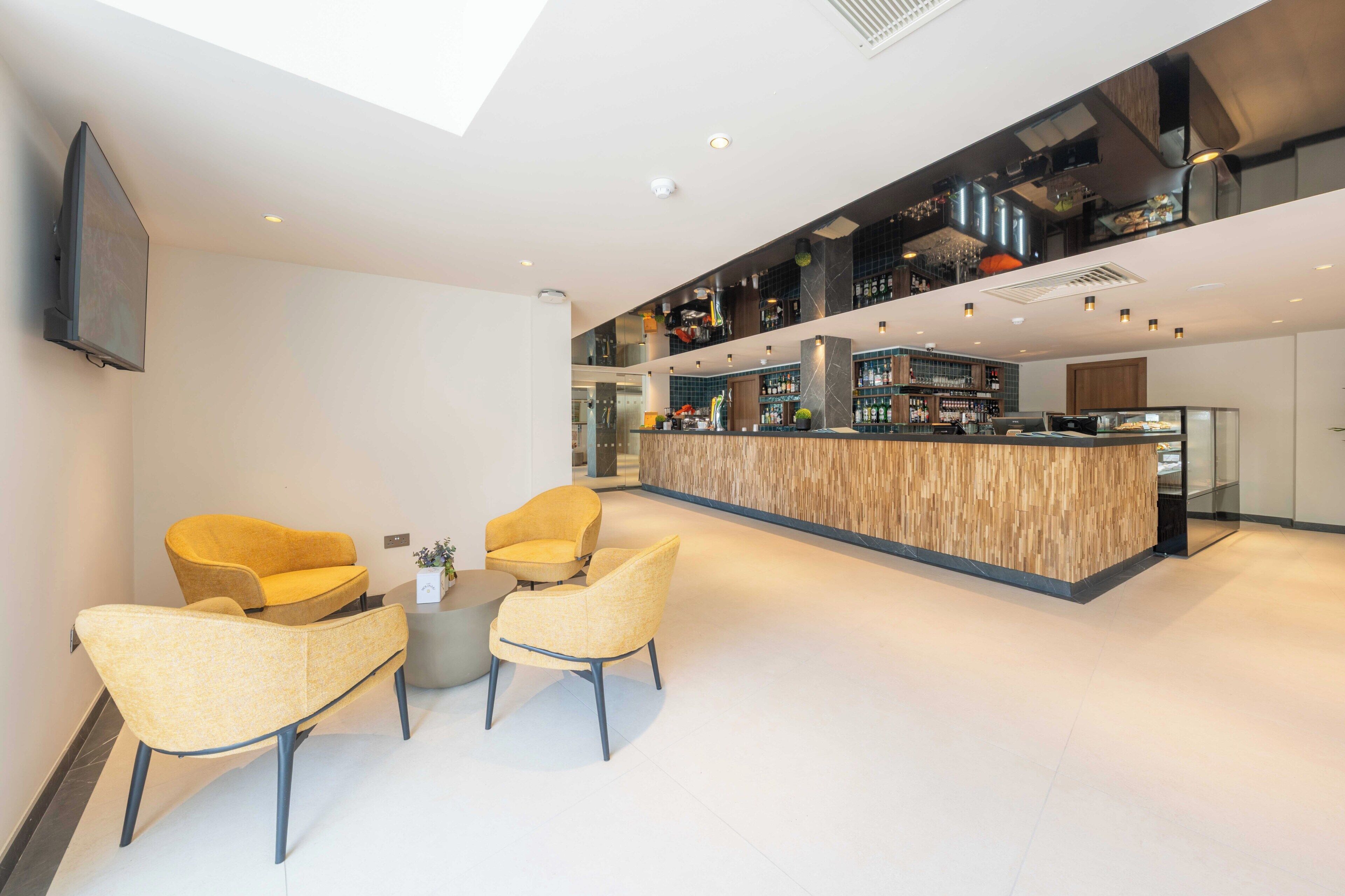 Ein modernes Interieur mit Bar, Sitzgelegenheiten und einem Flachbildfernseher.