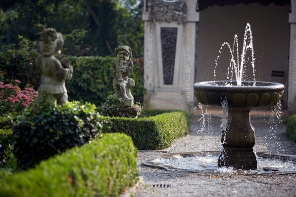 Ein Garten mit Brunnen und Statuen.