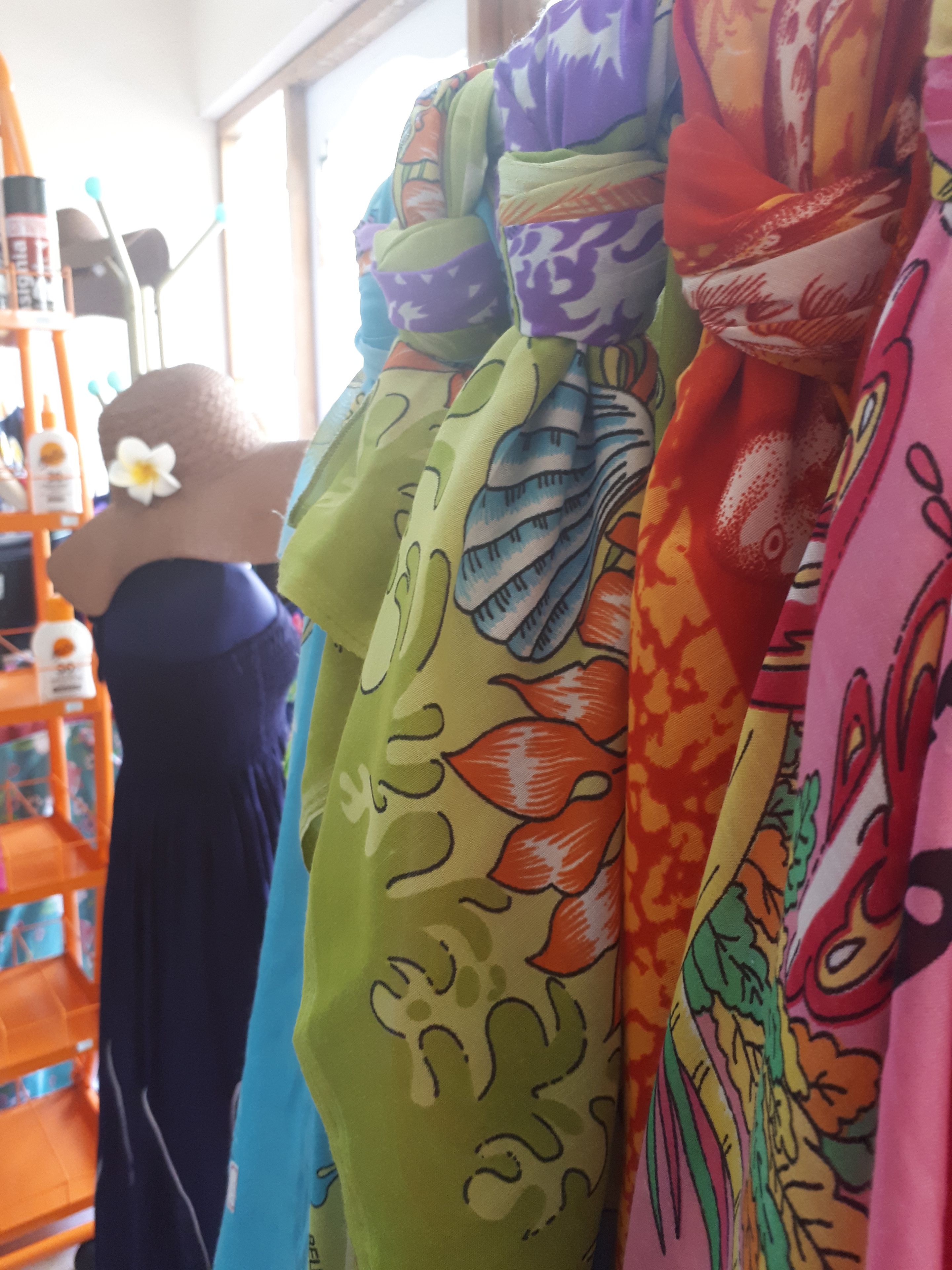 A variety of colorful fabrics displayed on a rack.