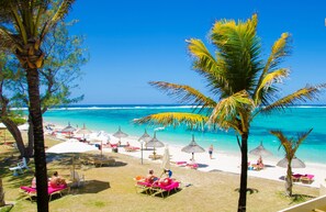 On the beach, white sand, sun-loungers, beach umbrellas