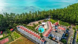An aerial view of a resort with a swimming pool, beach area, and multiple buildings with red roofs. - Tarisa Resort (Mont Choisy)