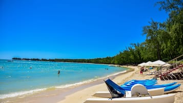 On the beach, white sand, sun loungers, beach umbrellas