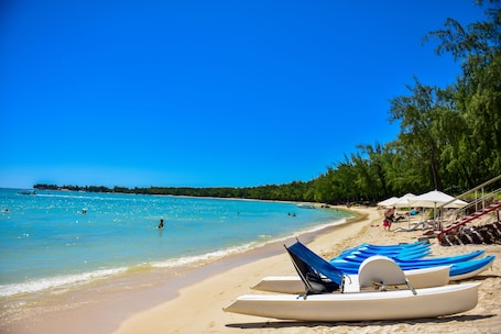 On the beach, white sand, sun loungers, beach umbrellas