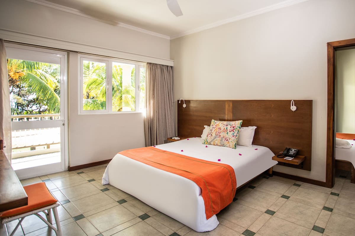 A hotel room with a bed, a desk, and a chair.