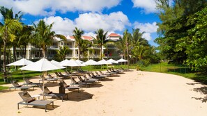 På stranden, hvit sand, solsenger og parasoller