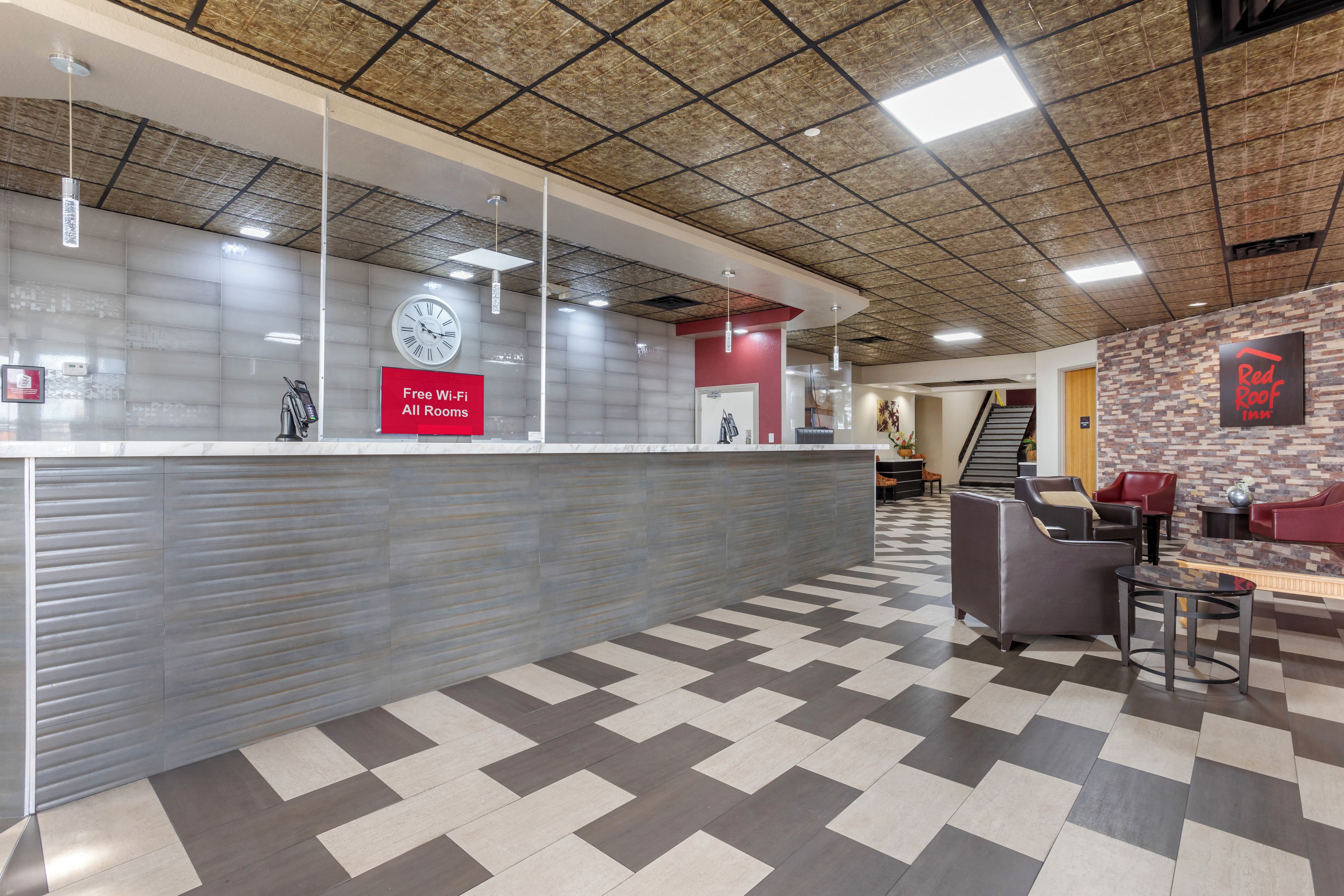 A reception area with a check-in counter, a clock, and a sign offering free Wi-Fi.